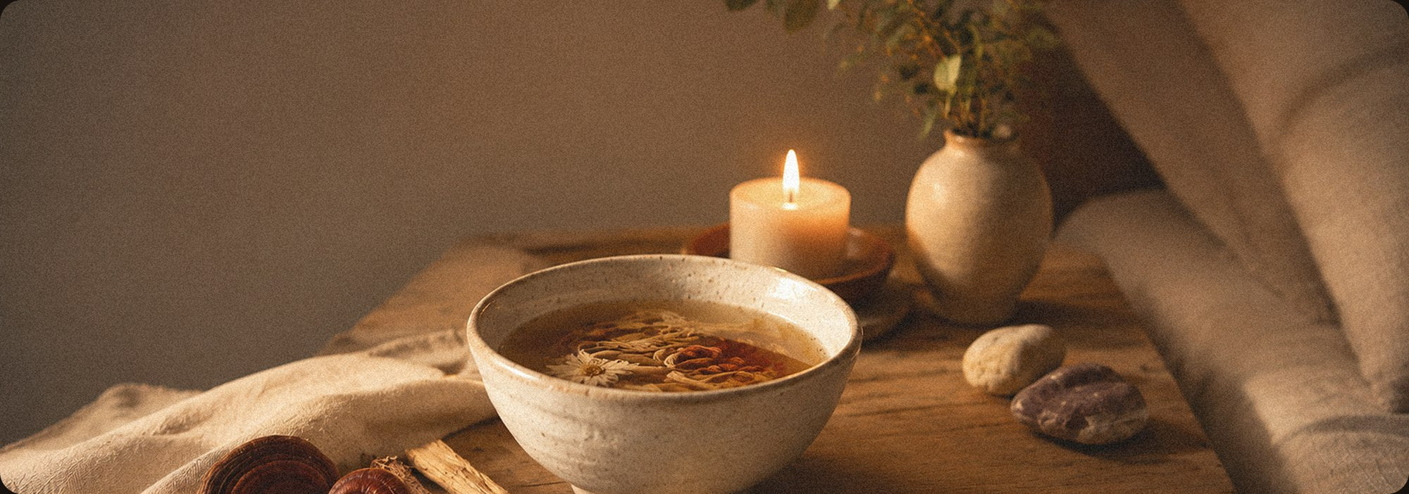 Warm botanical tea beside a candle for an evening wind-down ritual